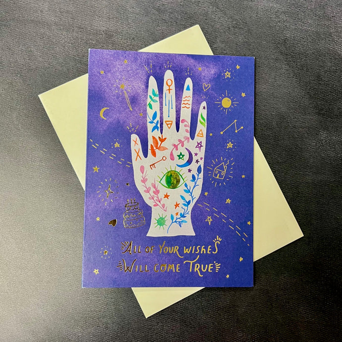 A blue card with an illustration of a hand with gold foil text that reads 